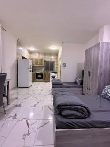 a living room with two beds and a kitchen at Makank Jo in Aqaba