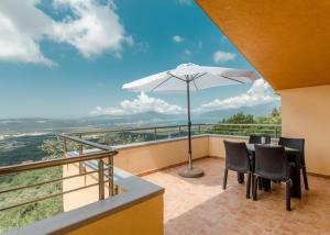 a balcony with a table and an umbrella at Apartment Panorama in Kotor