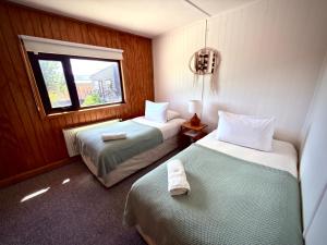 a hotel room with two beds and a window at Yagan house in Puerto Natales
