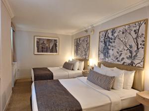 a hotel room with two beds and two paintings on the wall at Warwick Allerton Chicago in Chicago +63 photos