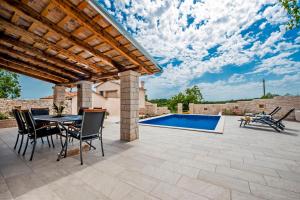 a patio with a table and chairs and a swimming pool at Villa Masi in Kanfanar