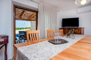 a dining room with a table and a television at Villa Masi in Kanfanar
