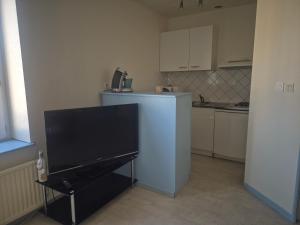 a small kitchen with a television and a refrigerator at Appartement proche Le Pal 3 in Dompierre-sur-Besbre