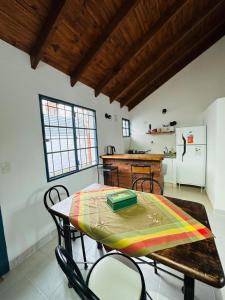 a kitchen with a table and a refrigerator at Solymar Alojamiento in Puerto Madryn +3 photos
