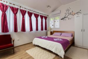 a bedroom with red curtains and a bed and a chair at Apartment Panorama in Kotor +41 photos