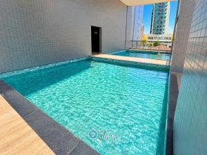a swimming pool with blue water in a building at Solaz Smart Living by 123Quarto in Tambaú