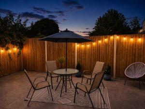 a patio with a table and chairs and an umbrella at Spacious En-suite Private Double Bedroom in Oxford