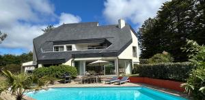a house with a swimming pool in front of it at Villa 96 Golf de la Baule avec piscine et spa in Saint-André-des-Eaux