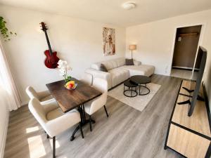 a living room with a couch and a table with a guitar at Topview 2BR Balcony & Mountain View Interlaken in Unterseen