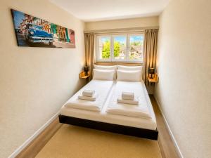 a small bed in a room with a window at Topview 2BR Balcony & Mountain View Interlaken in Unterseen