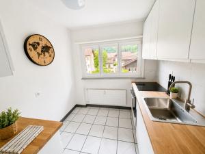 a kitchen with a sink and a clock on the wall at Topview 2BR Balcony & Mountain View Interlaken in Unterseen +14 photos