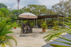 eine Terrasse mit Tisch und Sonnenschirm in der Unterkunft Hotel San Jeronimo Tropical in San Jerónimo