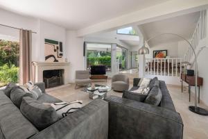 a living room with a couch and a fireplace at Villa 96 Golf de la Baule avec piscine et spa in Saint-André-des-Eaux