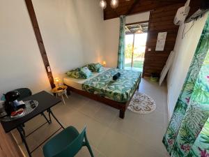 a bedroom with a bed and a table and chairs at Les gîtes Lanmou 1 in La Désirade