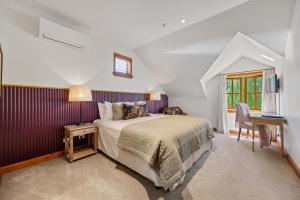 a bedroom with a bed and a desk and a window at Wanaka Homestead Lodge & Cottages in Wanaka