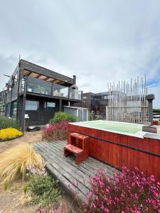 a bench on a wooden boardwalk in front of a building at PEZ HOUSE in Pichilemu