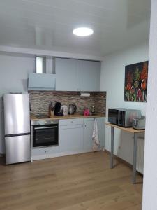 a kitchen with white cabinets and a stainless steel refrigerator at Anderer Apartment 2 in Liedolsheim