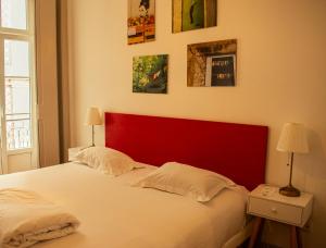 a bed with a red headboard in a bedroom at Inn Possible Lisbon Hostel in Lisbon