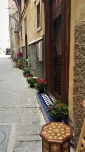 an alley with flowers and a table and a building at Riad Dar Cordoba in Fès