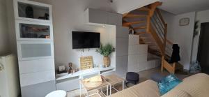 a living room with a couch and a stair case at L eden Maison en Camargue in Salin-de-Giraud
