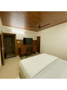 a bedroom with a bed and a flat screen tv at Hotel Walk Inn in Faridabad