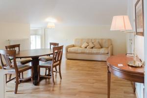 a living room with a table and chairs and a couch at Relais Villa Selle in Fumane