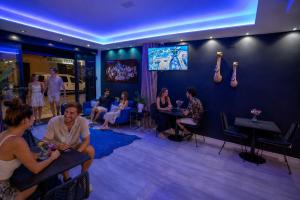 a group of people sitting in a room with a tv at Urban Spaces Ibiza in Ibiza Town