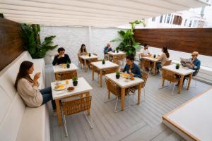 a group of people sitting at tables in a restaurant at Urban Spaces Ibiza in Ibiza Town