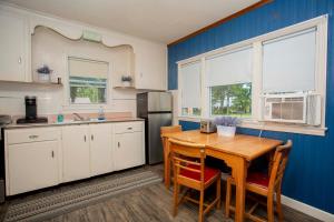 a kitchen with a wooden table and a refrigerator at Lake Huron Cottage 6 - 3 Bed 1 Bath in Lincoln Junction