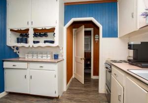 a kitchen with white cabinets and blue walls at Lake Huron Cottage 6 - 3 Bed 1 Bath in Lincoln Junction