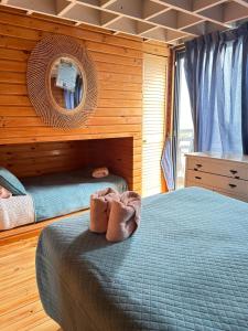 a bedroom with a bed and a mirror on the wall at PEZ HOUSE in Pichilemu