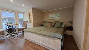 a bedroom with a large bed and a table at Bungalow am Wald in Coswig
