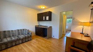a living room with a couch and a kitchen at Diplomat Motel in Nanaimo