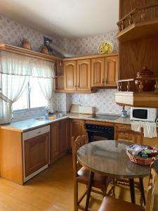a kitchen with wooden cabinets and a table in it at Casa Magdalena in Archidona