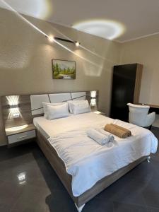 a bedroom with a large bed with two towels on it at La Mer Beach Residence in Ulcinj