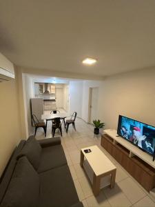 a living room with a couch and a flat screen tv at Departamento Posadas Temporario Céntrico Alquiler in Posadas