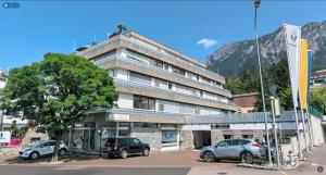 a building with two cars parked in a parking lot at Penthouse in Schaan in Schaan