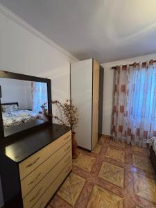 a bedroom with a dresser and a television in a room at Guest House Ajasllari in Çorovodë