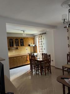 a dining room with a table and chairs in a kitchen at Guest House Ajasllari in Çorovodë +16 photos