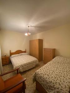 a bedroom with two beds and a dresser at Casa Magdalena in Archidona