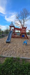 a playground with a slide and a gazebo at Kameralne Kładno in Łopienica