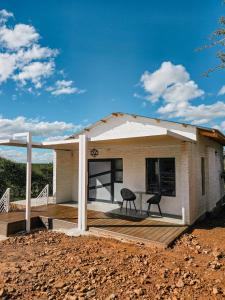 a small house with two chairs on a wooden deck at Orang Cottages BW in Ramotswa