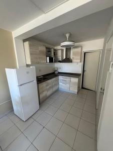 a kitchen with a refrigerator and a tile floor at Departamento Posadas Temporario Céntrico Alquiler in Posadas +3 photos