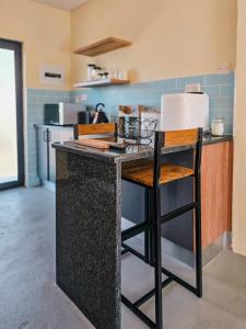 a kitchen with a counter with two stools in it at Orang Cottages BW in Ramotswa
