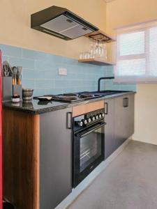 a kitchen with a stove and a sink at Orang Cottages BW in Ramotswa
