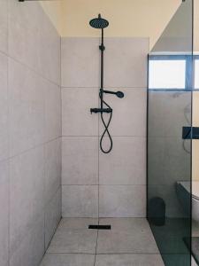 a shower with a glass door in a bathroom at Orang Cottages BW in Ramotswa