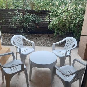 three white chairs and a table and a table and chairs at Rincon de Gulliver in Pinamar