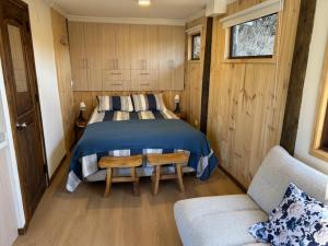 a bedroom with a bed and a chair and a couch at Cabañas y Lodges de Playa Ritoque RITOKAZO in Quintero