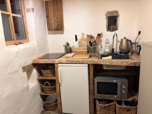 a kitchen with a counter with a sink and a microwave at L'Alterre Durbuy in Durbuy +47 photos