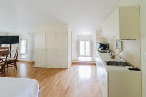 a kitchen with white cabinets and a wooden floor at Relais Villa Selle in Fumane